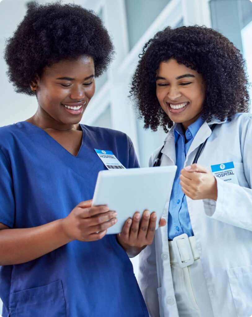 Two nurses using a table to use the ongoing competency component of the cloud-based platform, Creative Health Care Insight