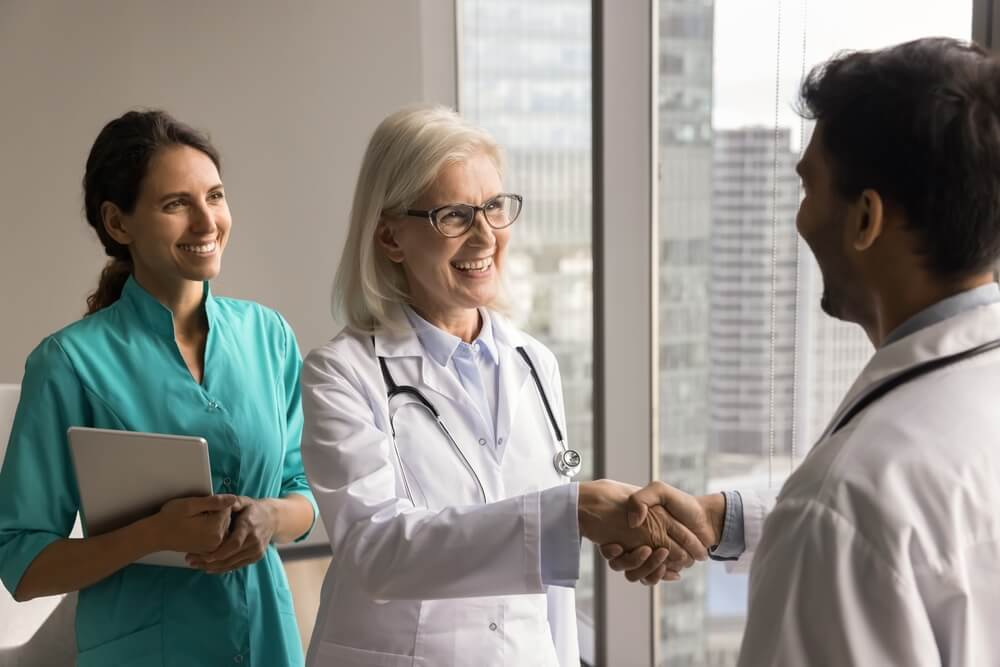 A new hire shakes hands with a preceptor during the new hire onboarding process.